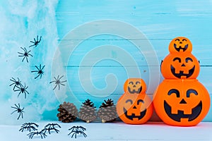 Halloween holiday background with spider, webs and jack lantern on blue wooden table with copy space for text. Flat lay, top view