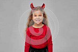 Girl in halloween costume and devil`s horns