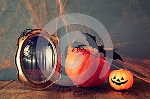 Halloween holiday concept. Cute pumpkin, bats and old frame