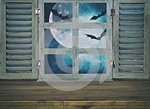 Halloween holiday concept. Empty rustic table in front of haunted night sky background and old window. Ready for product display m