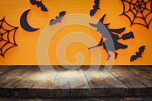 Halloween holiday concept with empty rustic table over orange background. Ready for product display montage