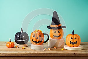 Halloween holiday concept with jack o lantern glitter pumpkin decor and candy corn on wooden table over blue background