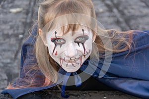 Halloween .. Holiday Day of the Dead. Close-up portrait of a happy and smiling a zombie girl on the roof of the house. The monster