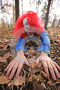 Halloween holiday. A scary evil clown.Halloween carnival party outdoors.