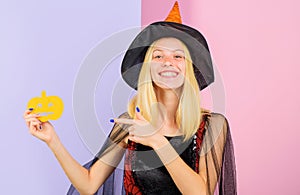 Halloween holiday. Smiling woman with paper pumpkin. Happy girl in Witch hat. 31 October.