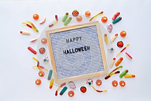 Halloween holiday sweets with gray letter board with words Happy Halloween flat lay on white background