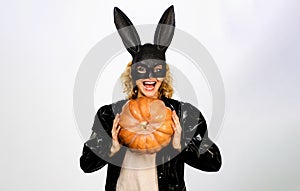 Halloween holidays celebration. Happy woman in Halloween bunny mask with pumpkin. Halloween party. Smiling sexy girl in