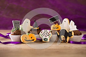 Halloween homemade cookies and cupcakes on purple spider backgro