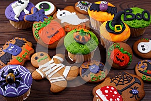 Halloween homemade gingerbread cookies and cupcakes background.