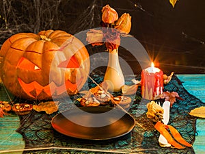 Halloween image of table with pumpkin, burning candle,
