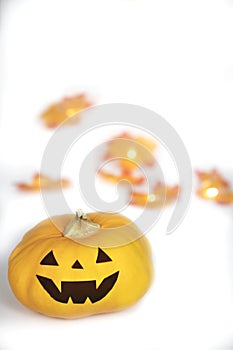 Halloween Jack O Lantern with autumn foliage isolated on white background, Pumpkin head on coloful leaves, spooky smile