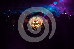 halloween jack-o-lantern on autumn leaves. Scary Halloween Pumpkin looking through the smoke. Glowing