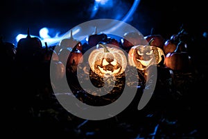 halloween jack-o-lantern on autumn leaves. Scary Halloween Pumpkin looking through the smoke. Glowing