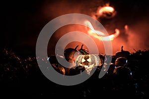 halloween jack-o-lantern on autumn leaves. Scary Halloween Pumpkin looking through the smoke. Glowing