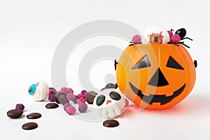 Halloween Jack o Lantern pumpkin bucket, Mashmallow in shape skull, candies and spiders on white background.