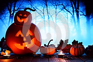 Halloween Jack o Lanterns against spooky blue lit forest