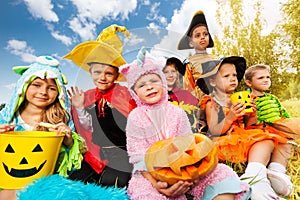 Halloween kids in beautiful costumes sitting