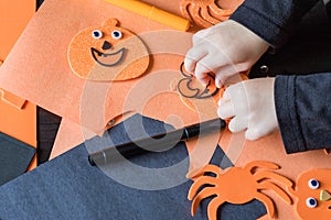 Halloween kids craft preparations. Little child doing autumn crafts at school or kindergarten