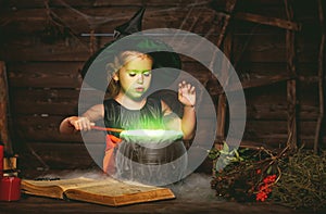 Halloween. little witch child cooking potion in cauldron with