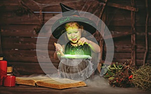 Halloween. little witch child cooking potion in cauldron with