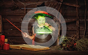 Halloween. little witch child cooking potion in cauldron with