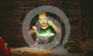 Halloween. little witch child cooking potion in cauldron with