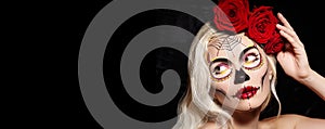 Halloween Make-Up Style. Blond Model Wear Sugar Skull Makeup with Red Roses. Dia de los Muertos or Santa Muerte concept