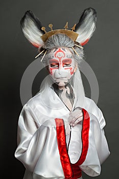 Halloween makeup. Portrait of cute woman wearing carnival mask on black background