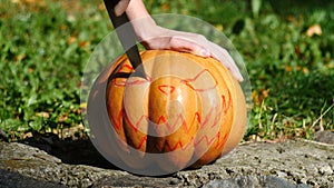 Halloween. Man carves a face in a pumpkin to make a jack o`lantern.