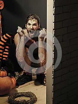 Halloween man shouting with anger in black net pantihose