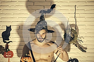 Halloween man in witch hat with pumpkin