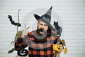 Halloween man in witch hat shouting with pumpkin