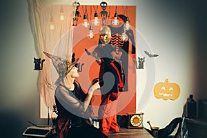 Halloween for mother and son. Children play with mother with pumpkins and treat. Halloween decoration and scary concept