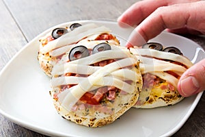 Halloween mummies mini pizzas on wood