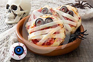 Halloween mummies mini pizzas on wood