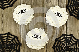 Halloween mummy cupcakes over wood