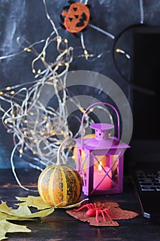 Halloween mystical decor, lantern with burning candle, autumn leaves on a black background, decorated home interior for the holida