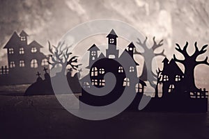 Halloween night background. Paper art. Abandoned village in a dark misty forest