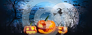 Halloween night with horrifying pumpkins,tombstones and cemetery spooky scary,witch flying in air,moon and sky background with