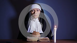 Halloween. nun prays. shadows in the form of devil. exorcism