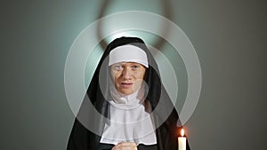 Halloween. nun prays. shadows in the form of devil. exorcism