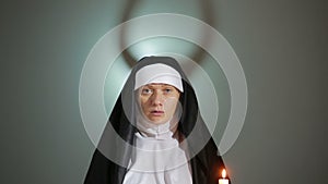 Halloween. nun prays. shadows in the form of devil. exorcism