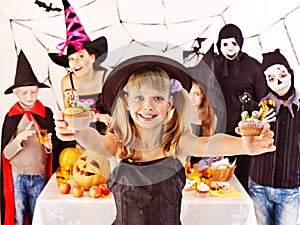 Halloween party with children holding trick or treat.