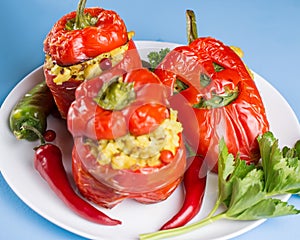 Halloween party food. Red stuffed peppers with scary cutout faces close up