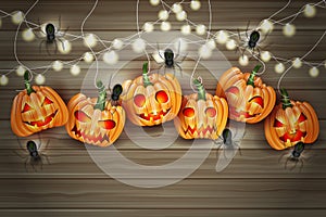 Halloween party illustration design with creepy pumpkin faces, haning lights, and spiders over brown wooden board background. photo