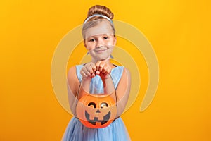 Halloween party. Little girl dressed as Cinderella on a yellow background.