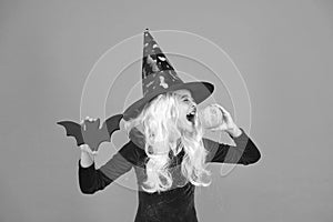 Halloween party. Small girl in black witch hat. Autumn holiday. Join celebration. Magical spell. Small witch with white