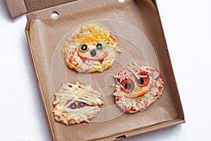 Halloween pizza with monsters, above scene with decor on a craft paper box background, idea for home party food, easy, healthy