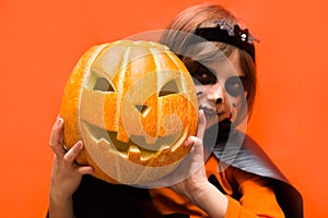 Halloween. Portrait of a girl made up on an orange background