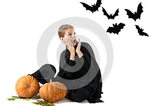 Halloween portrait of the surprised and frightened girl in the witch costume